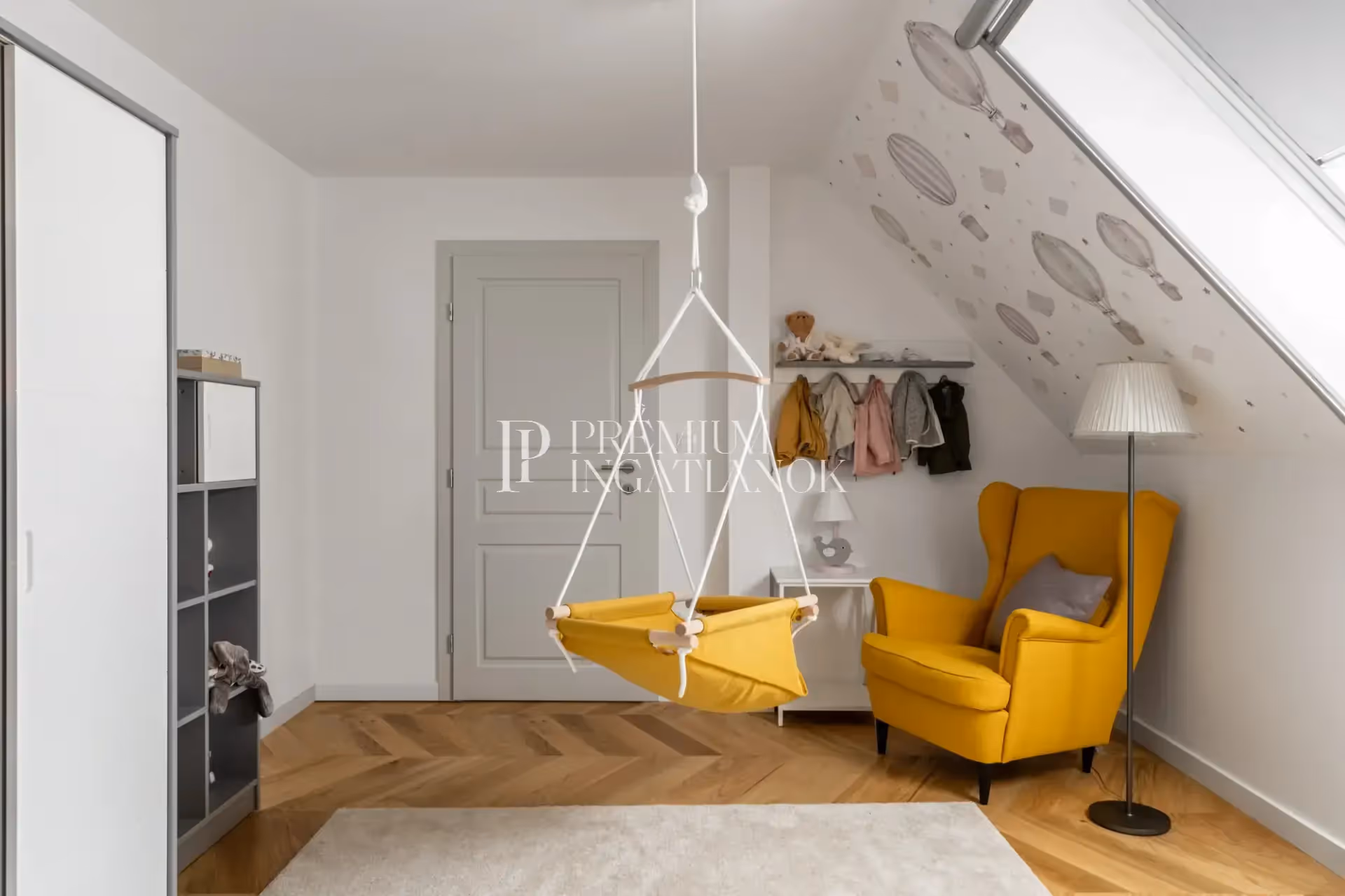 Világos gyerekszoba hőlégballonos falmatricával és különleges függő bölcsővel.