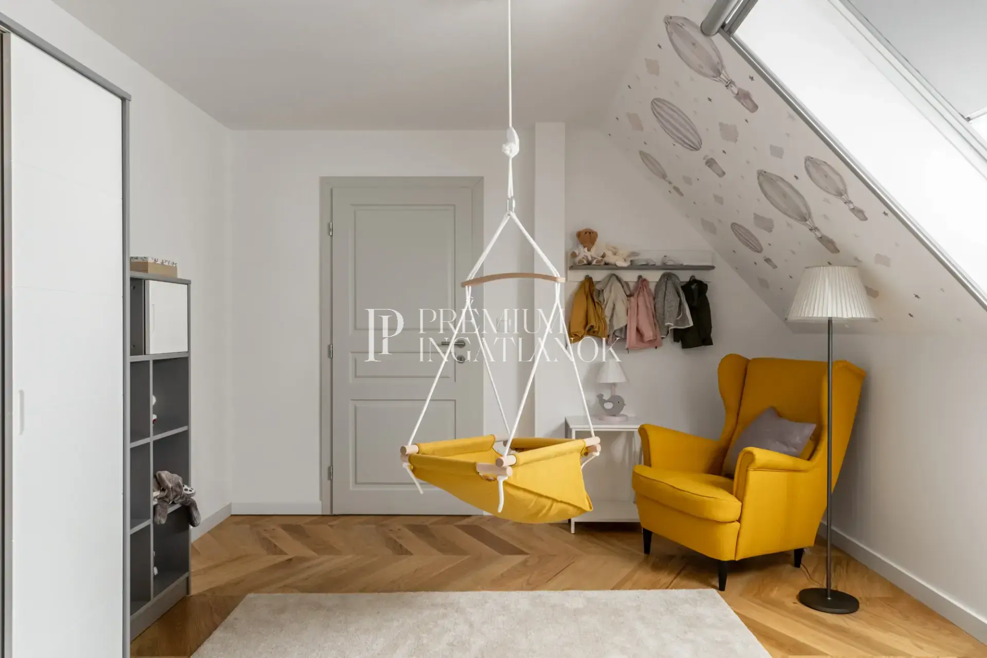 Világos gyerekszoba hőlégballonos falmatricával és különleges függő bölcsővel.