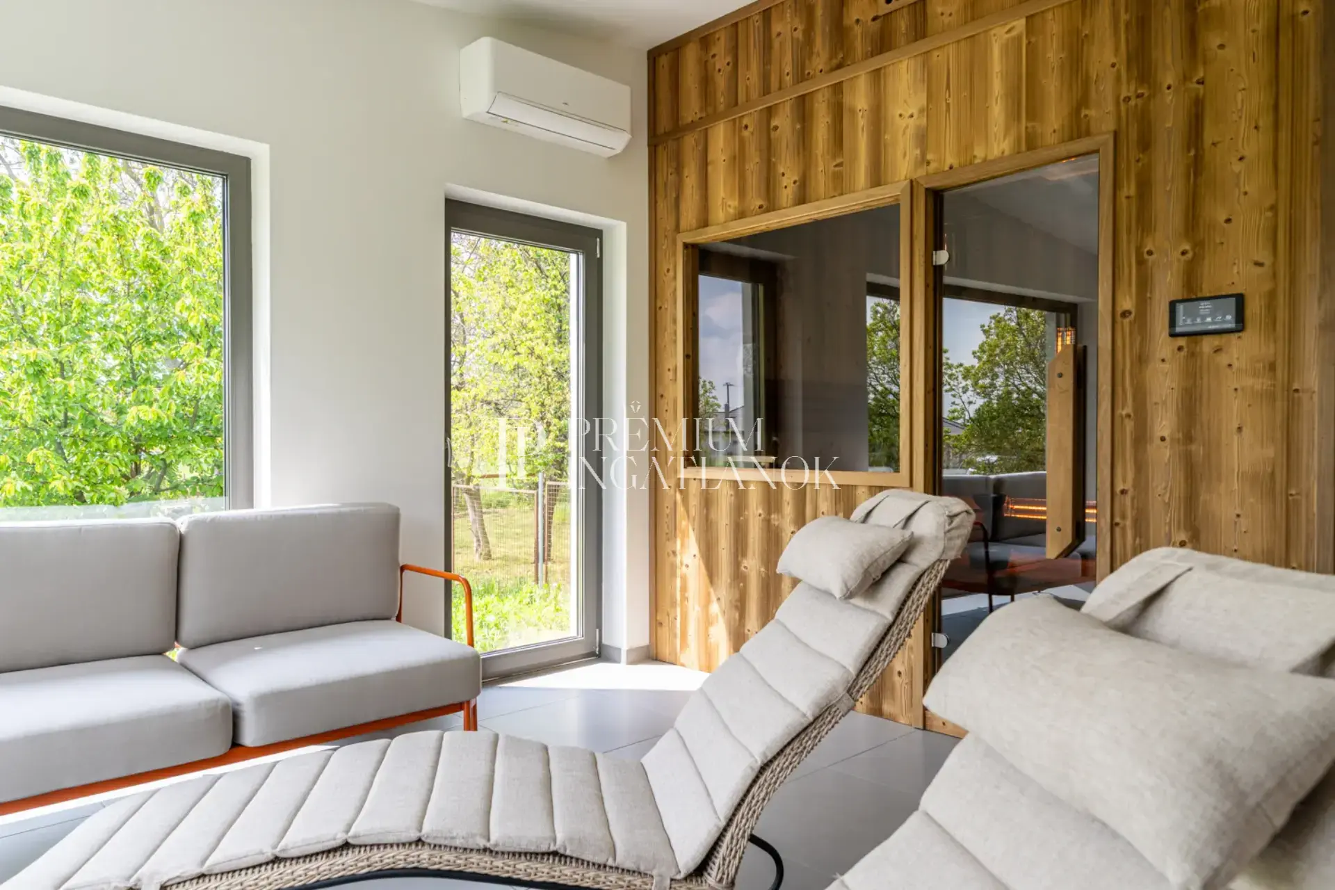 Üvegfalú finn szauna panorámás kilátással a szári ingatlan parkosított kertjére és a Vértes lankáira