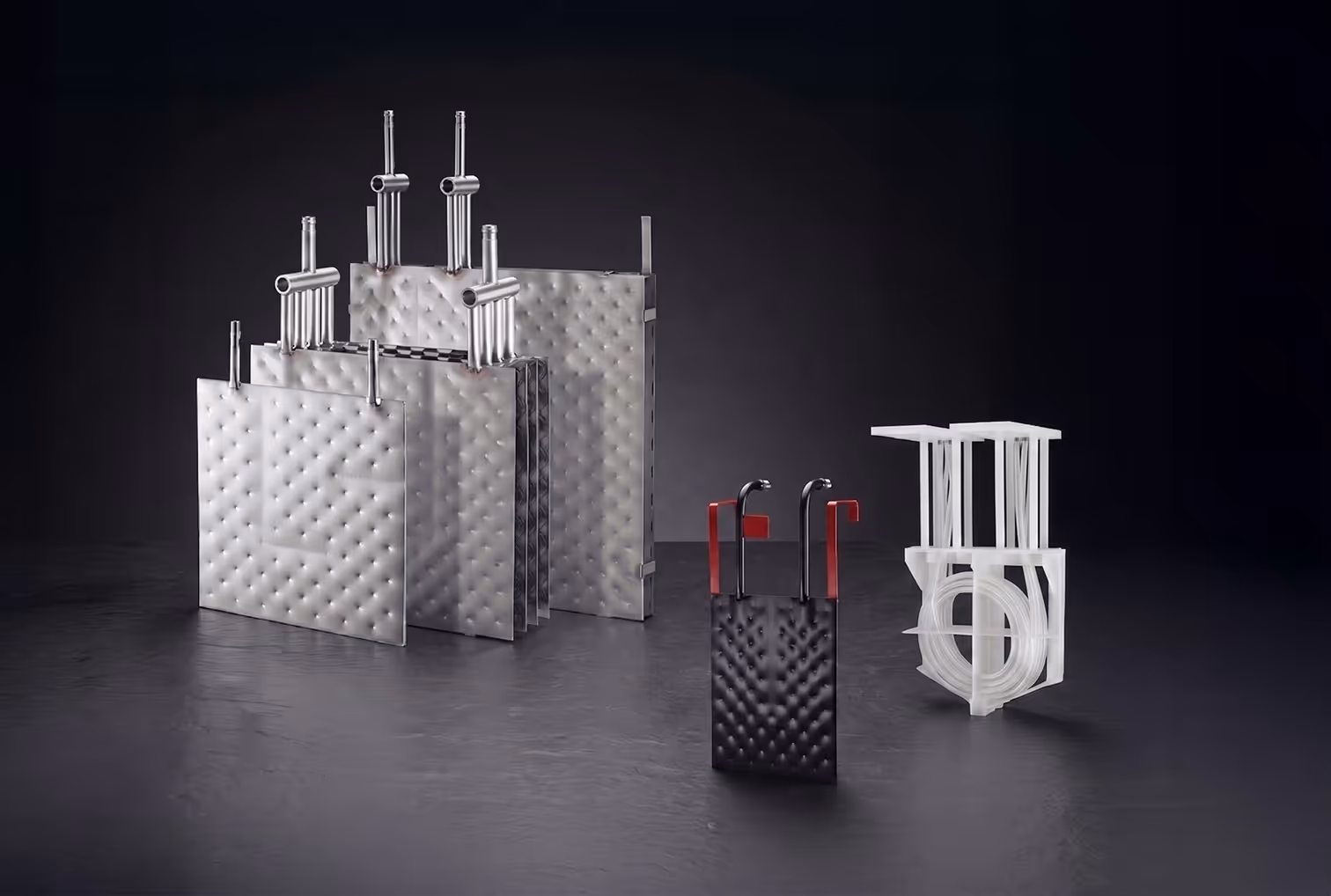 Verschillende metalen en kunststof plaatmaterialen met buisvormige uitsteeksels op een donkere vloer.