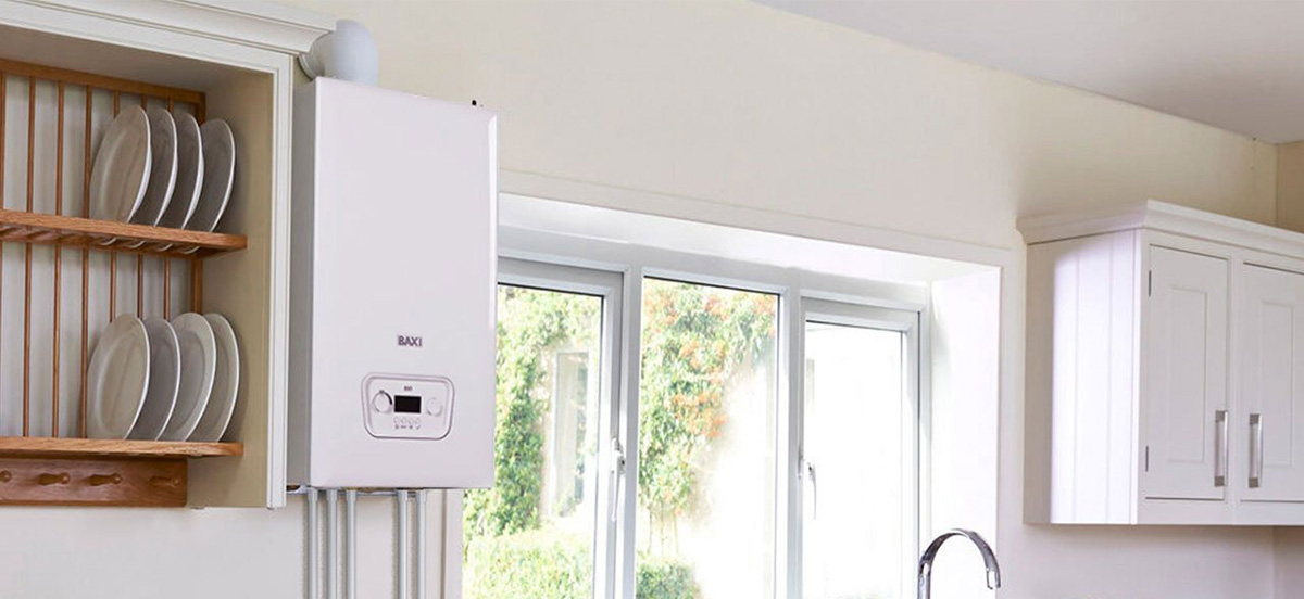 Modern kitchen interior with a white Baxi boiler mounted on the wall near a window and white cabinets.