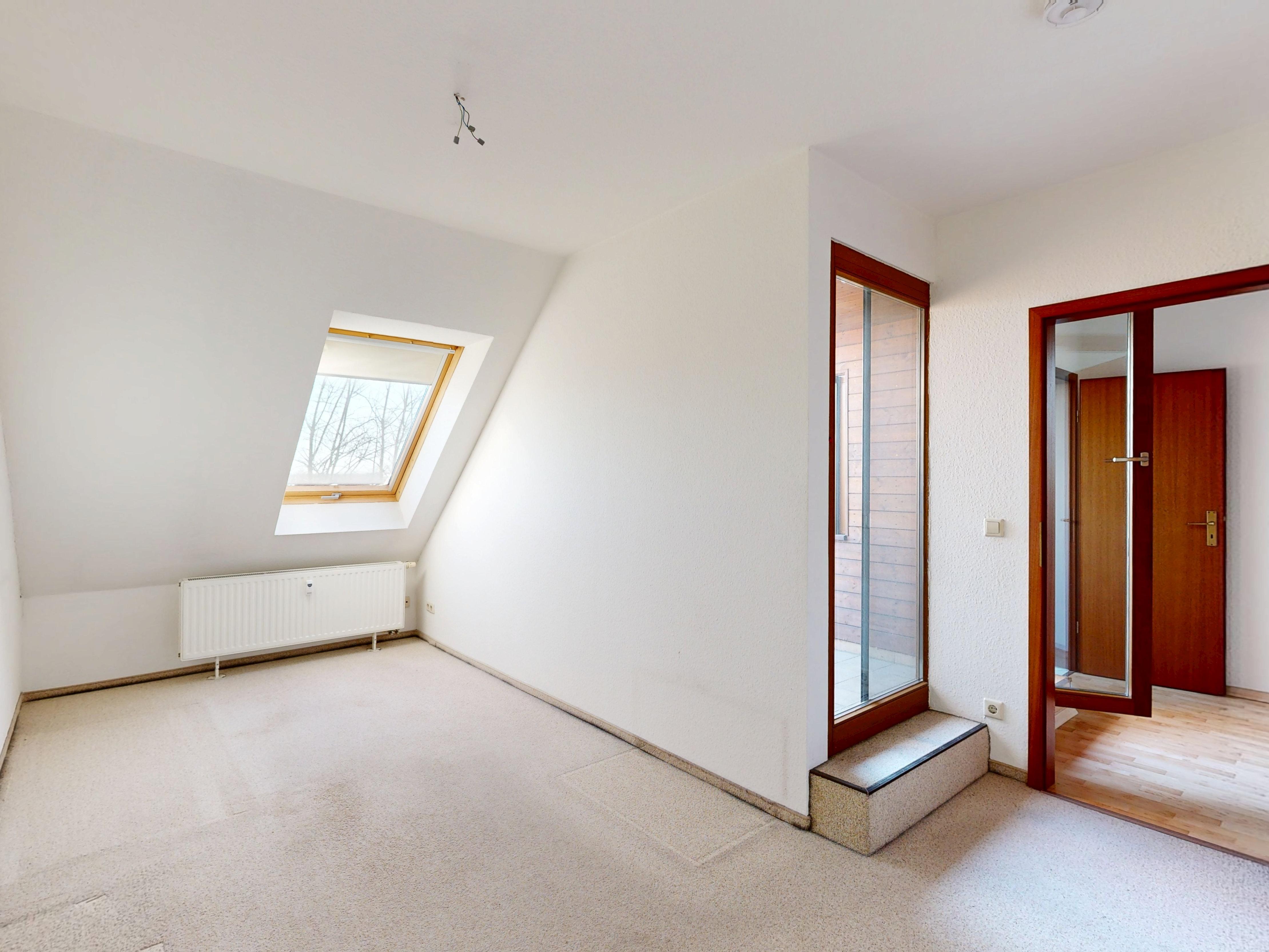 Zimmer mit Balkontür vor der Sanierung mit Teppichboden und Bestandstüren