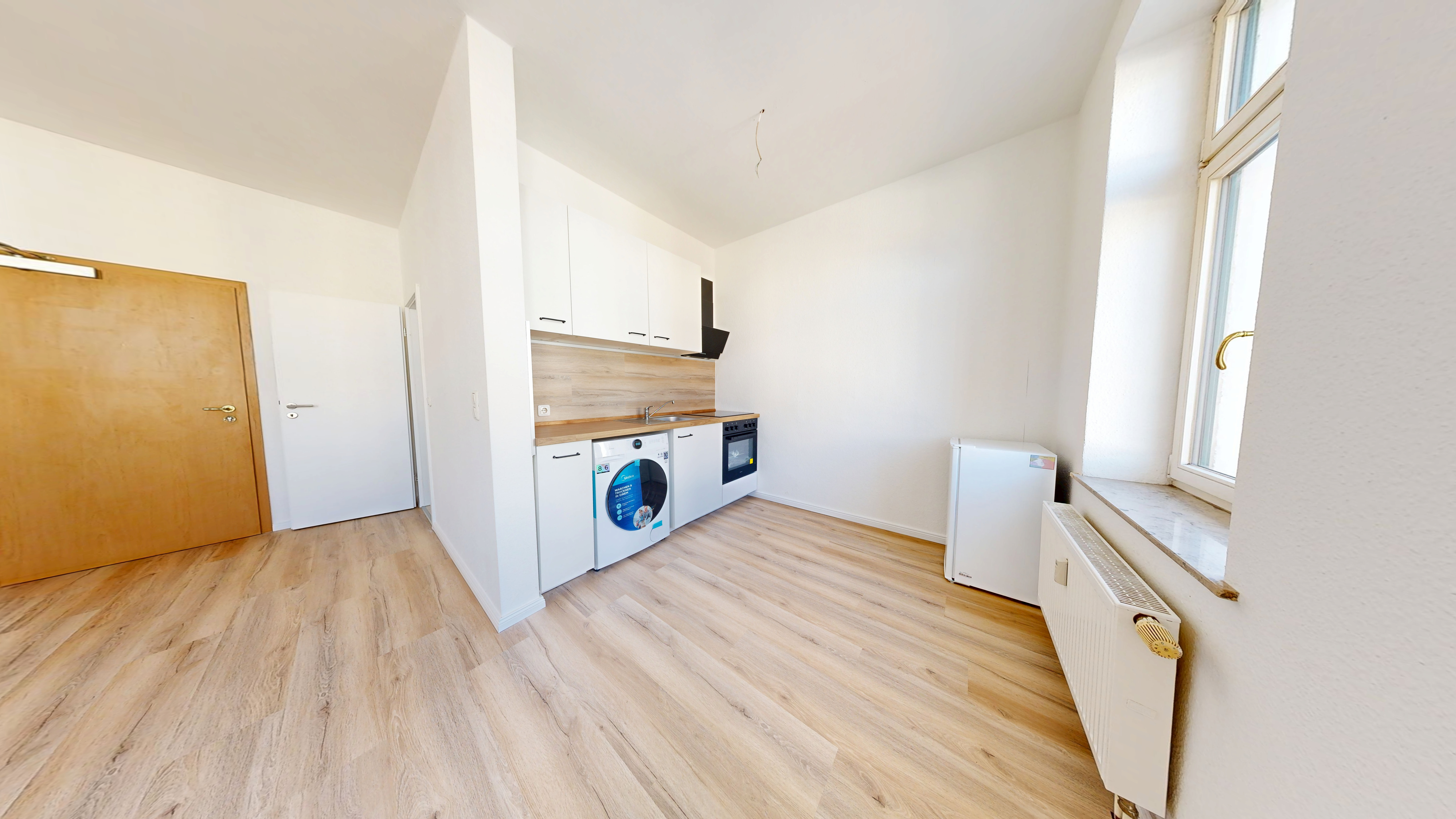 Küchenbereich nach der Sanierung mit neuer Einbauküche und Designboden