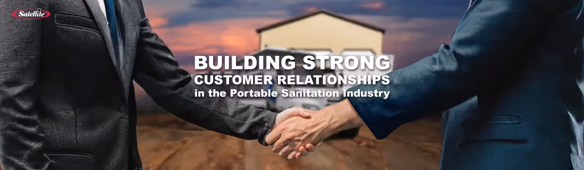 Two professionals shake hands in front of a portable sanitation facility, symbolizing trust, partnership, and strong customer relationships in the portable restroom industry.