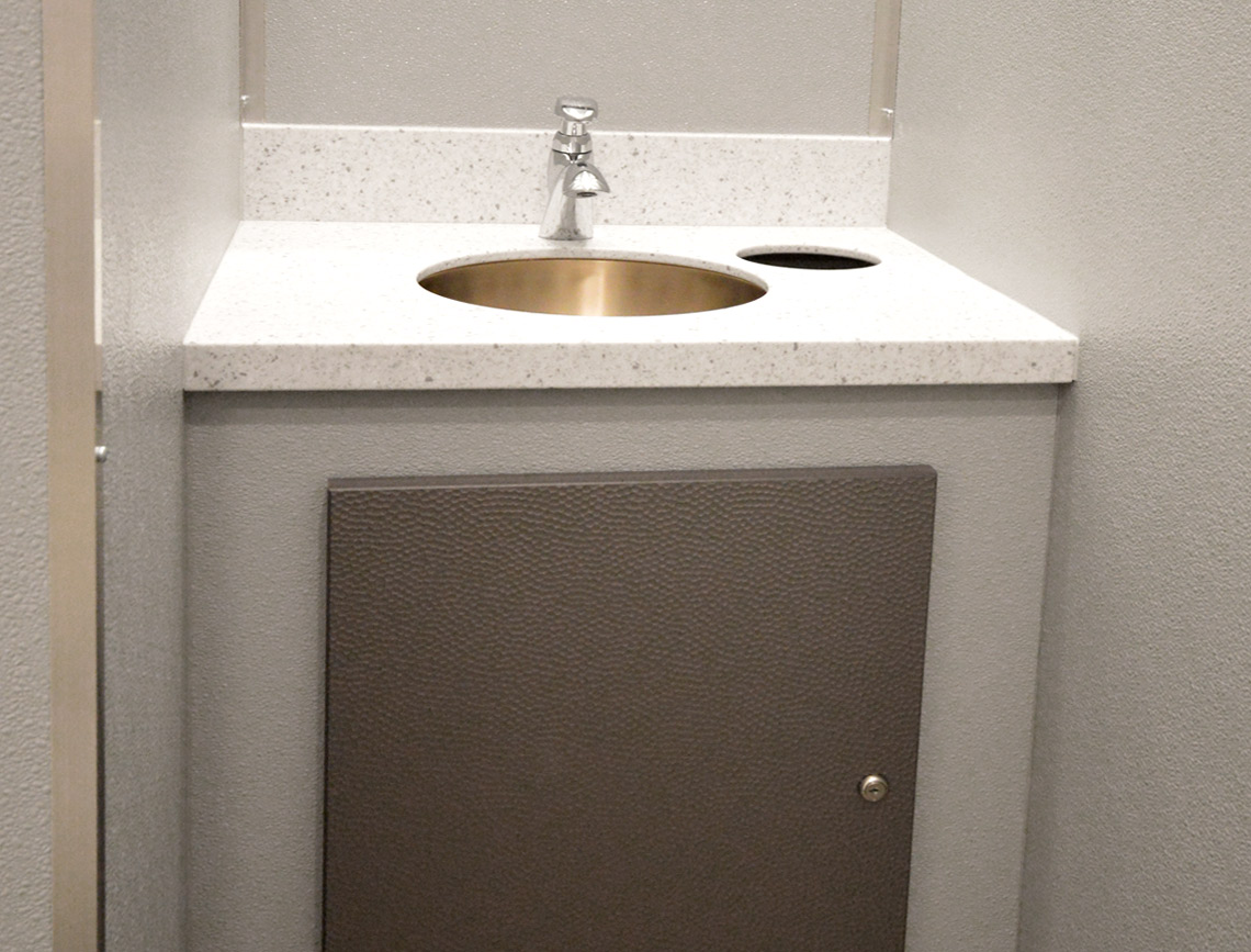 interior of a luxury restroom trailer showing high-end finishes like marble-style countertops and wood-grain flooring - luxury mobile restroom trailers