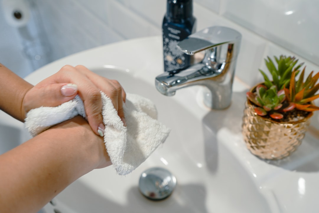 someone drying their hands with a paper towel - hot water hand washing