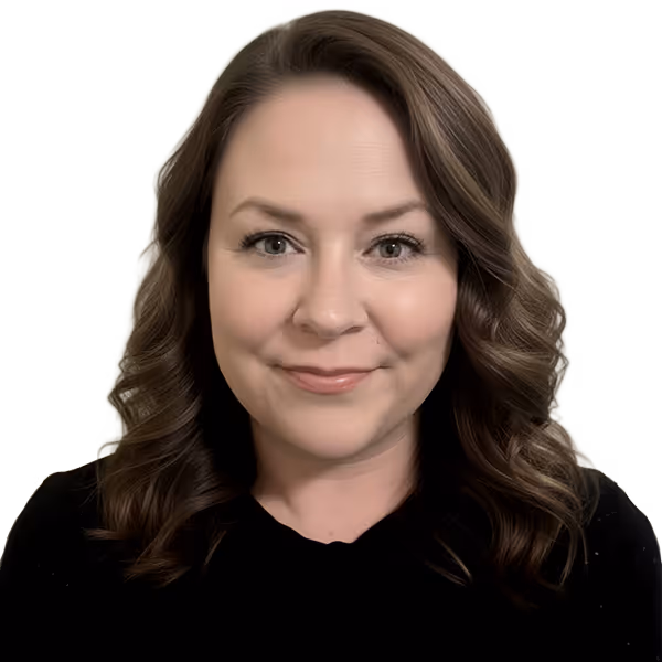 Smiling woman with wavy brown hair, light makeup, and black top against a neutral background.