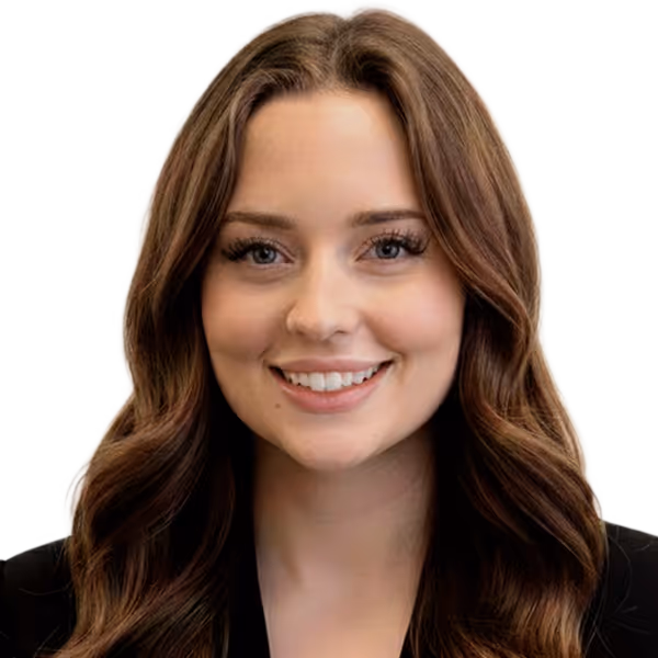 Smiling woman with long wavy brown hair wearing a black top on a white background.