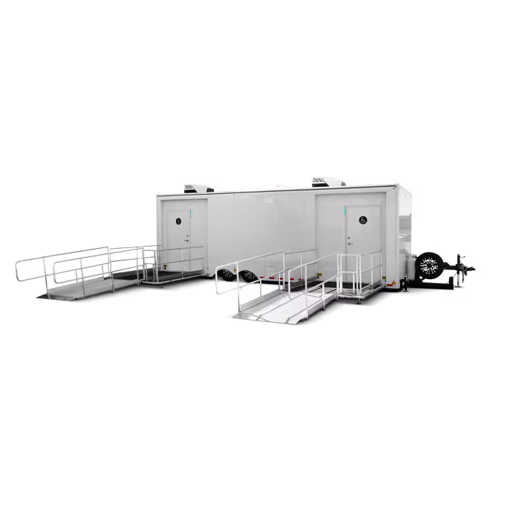 Mobile ADA-compliant trailer with two ramps and doors, one marked wheelchair accessible.