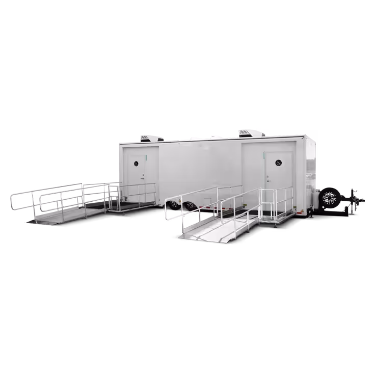 Portable trailer with two handicap accessible ramps leading to separate entrance doors.