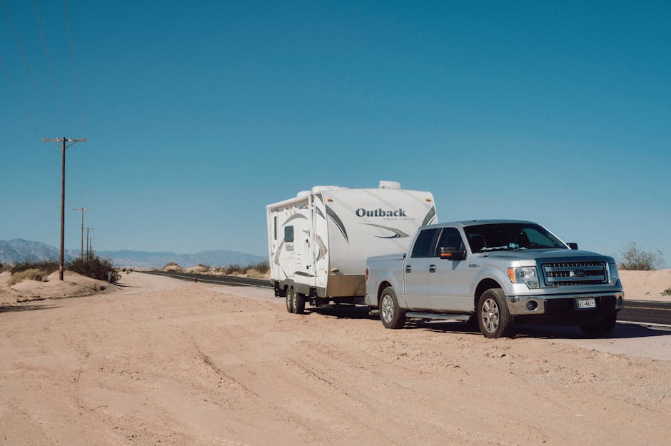 A truck towing a shower trailer on an unpaved road - Disaster relief showers