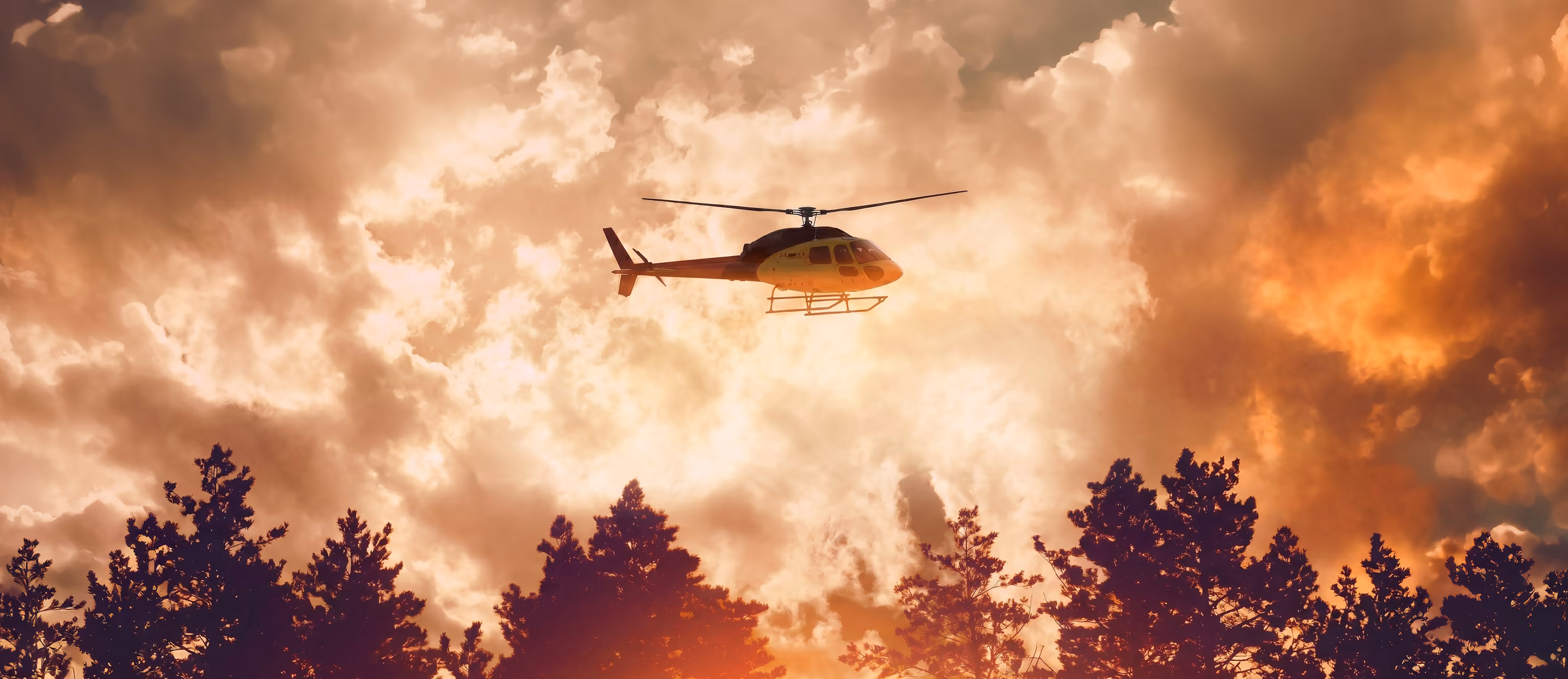 Helicopter flying over an active wildfire during a natural disaster response operation, highlighting emergency preparedness, disaster relief, portable sanitation planning, and critical infrastructure support for first responders and displaced communities.