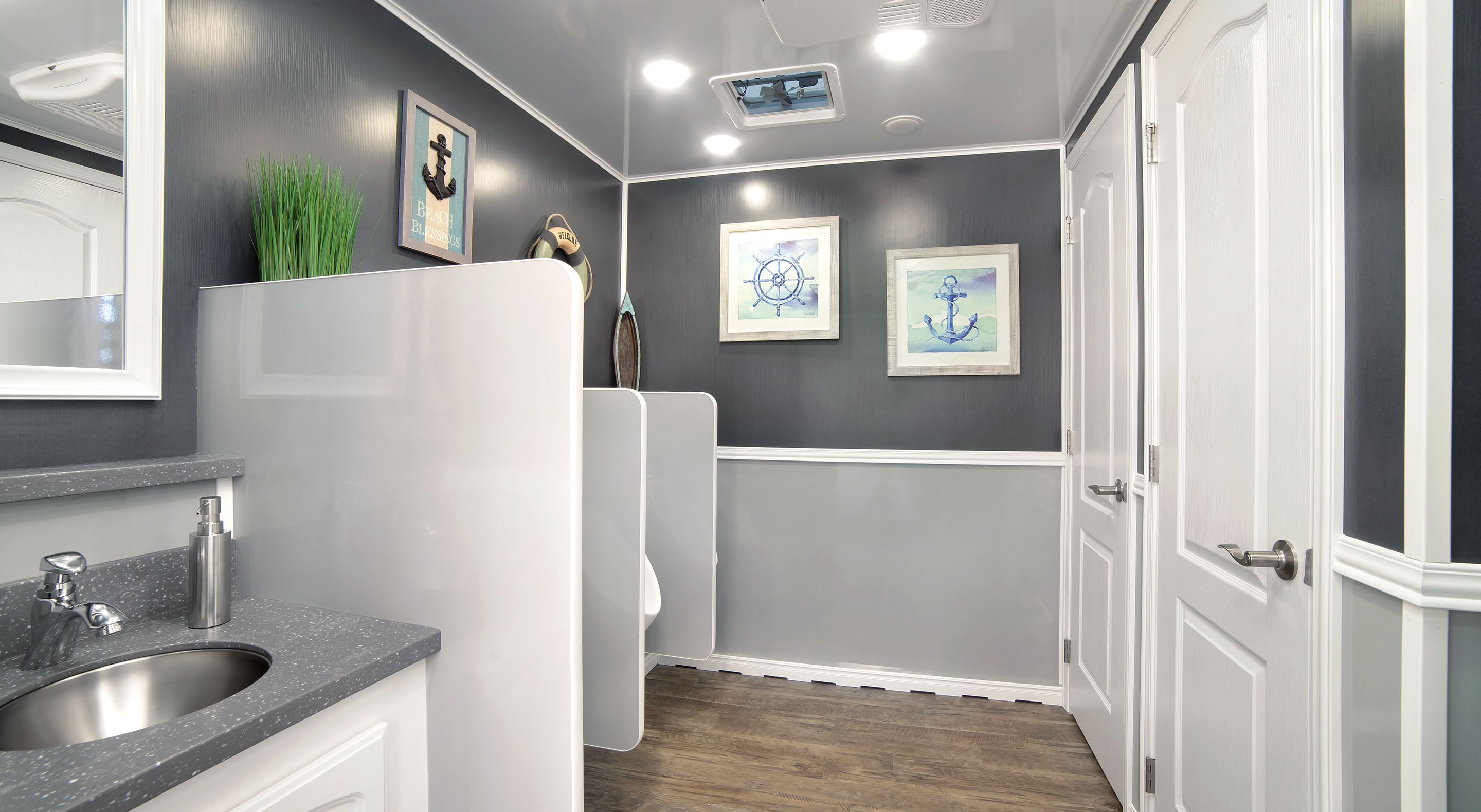 Modern bathroom featuring gray walls, sink, decorative nautical art, and a spacious layout.