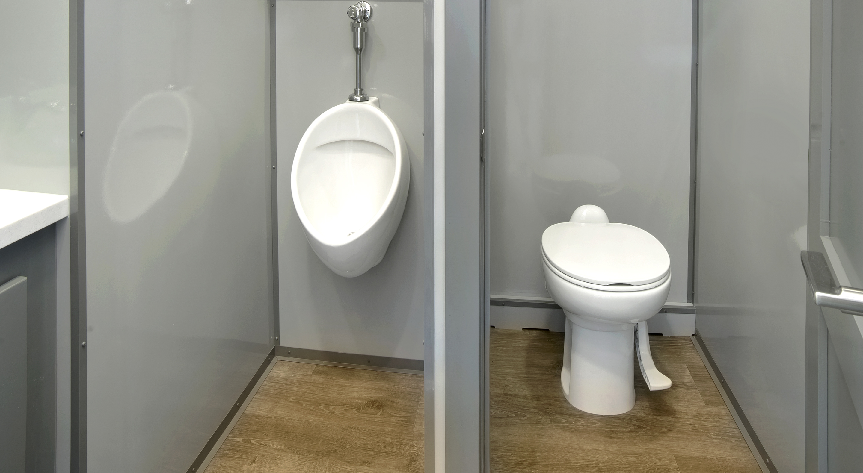 Men's restroom with a urinal on the left and a toilet on the right, separated by partitions.