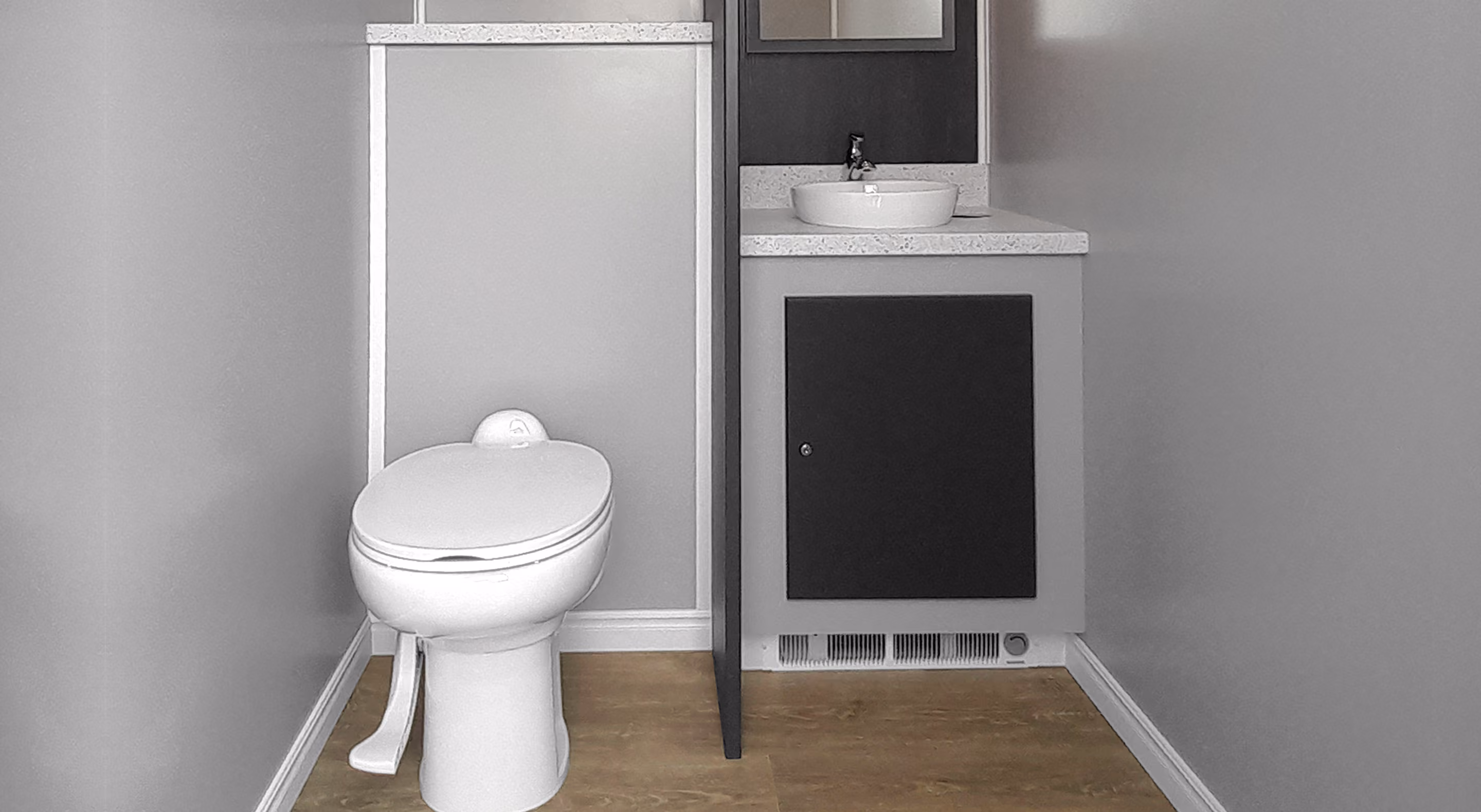 Modern bathroom featuring a toilet and a small sink with a mirror above it, light gray walls.