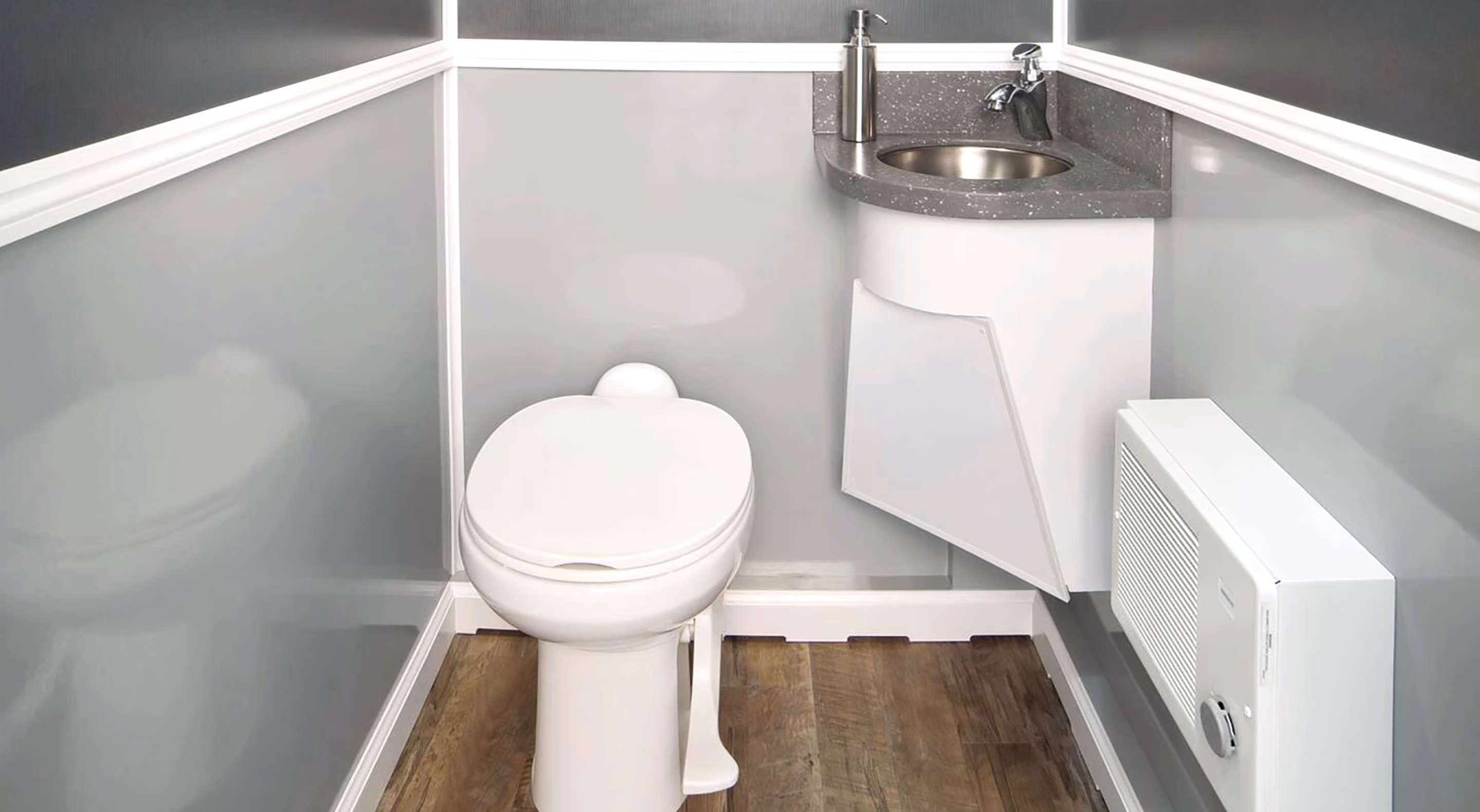 Compact bathroom interior featuring a toilet, sink, and heater against gray walls.
