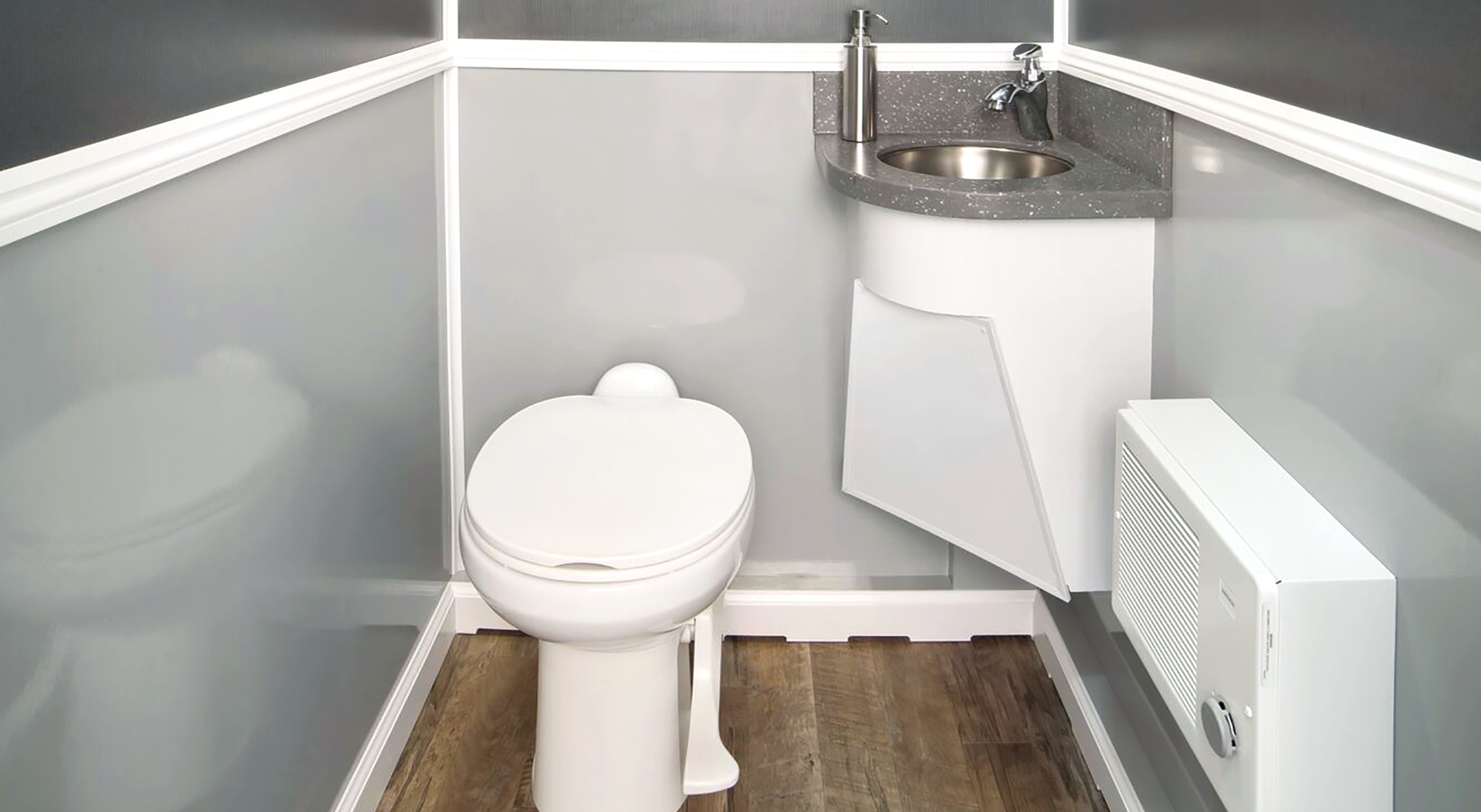 Compact bathroom interior featuring a toilet, sink, and heater against gray walls.