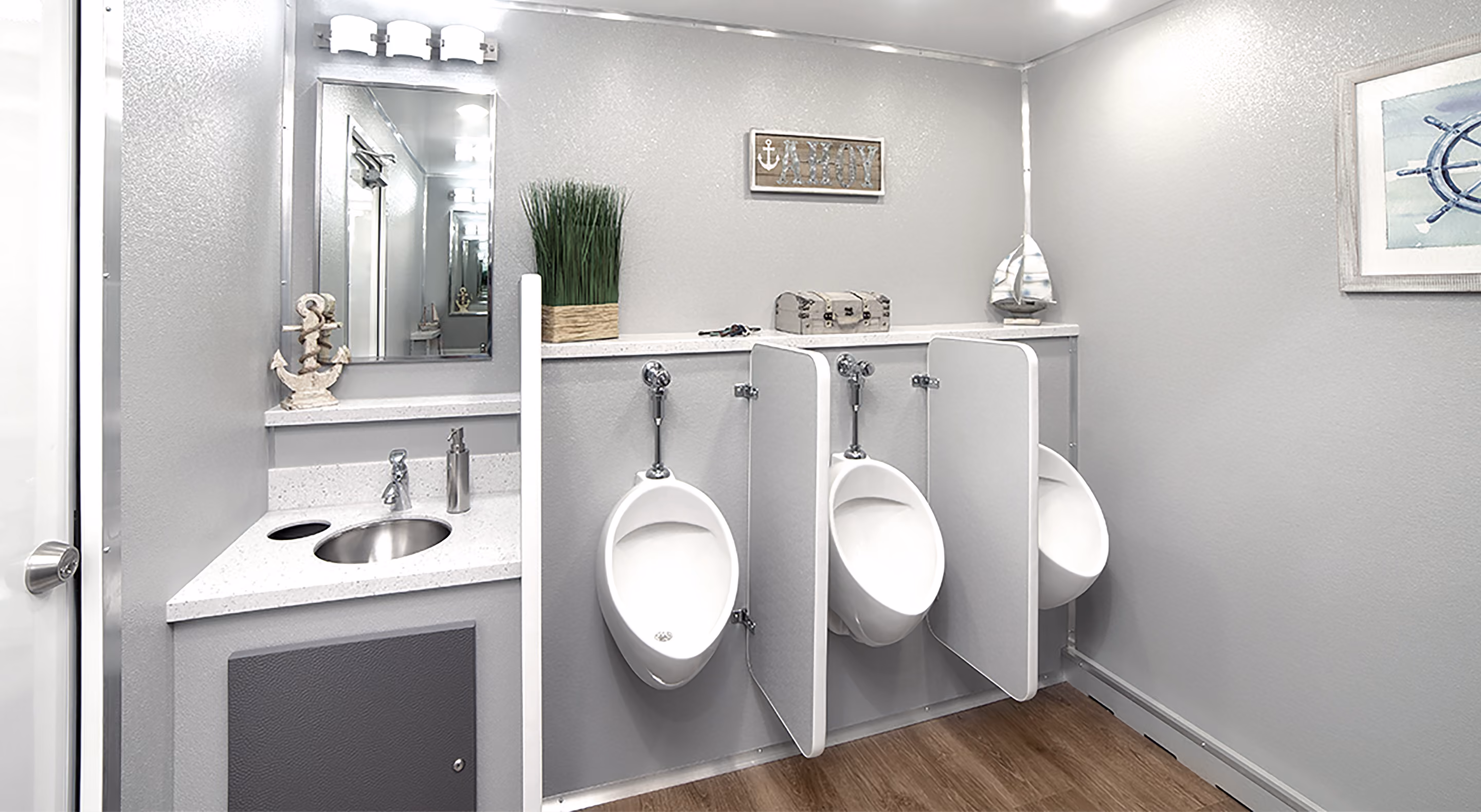 Clean men's restroom with three urinals, a sink, wood floor, and nautical-themed decor.