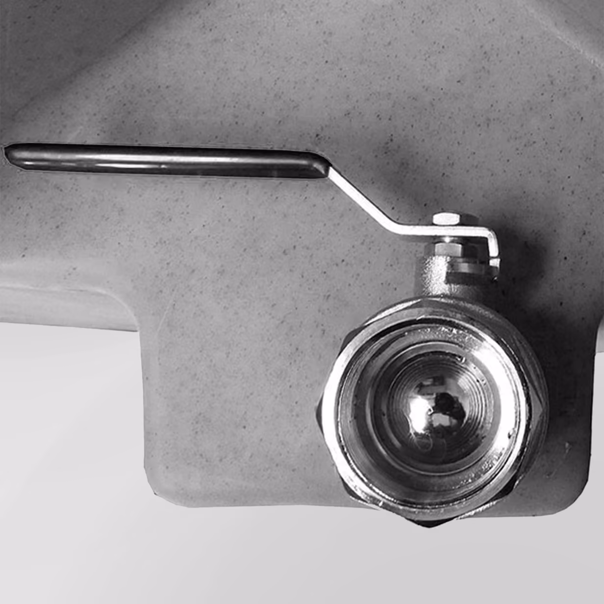 Metal valve with a handle attached to a gray tank, designed for concealed drainage.