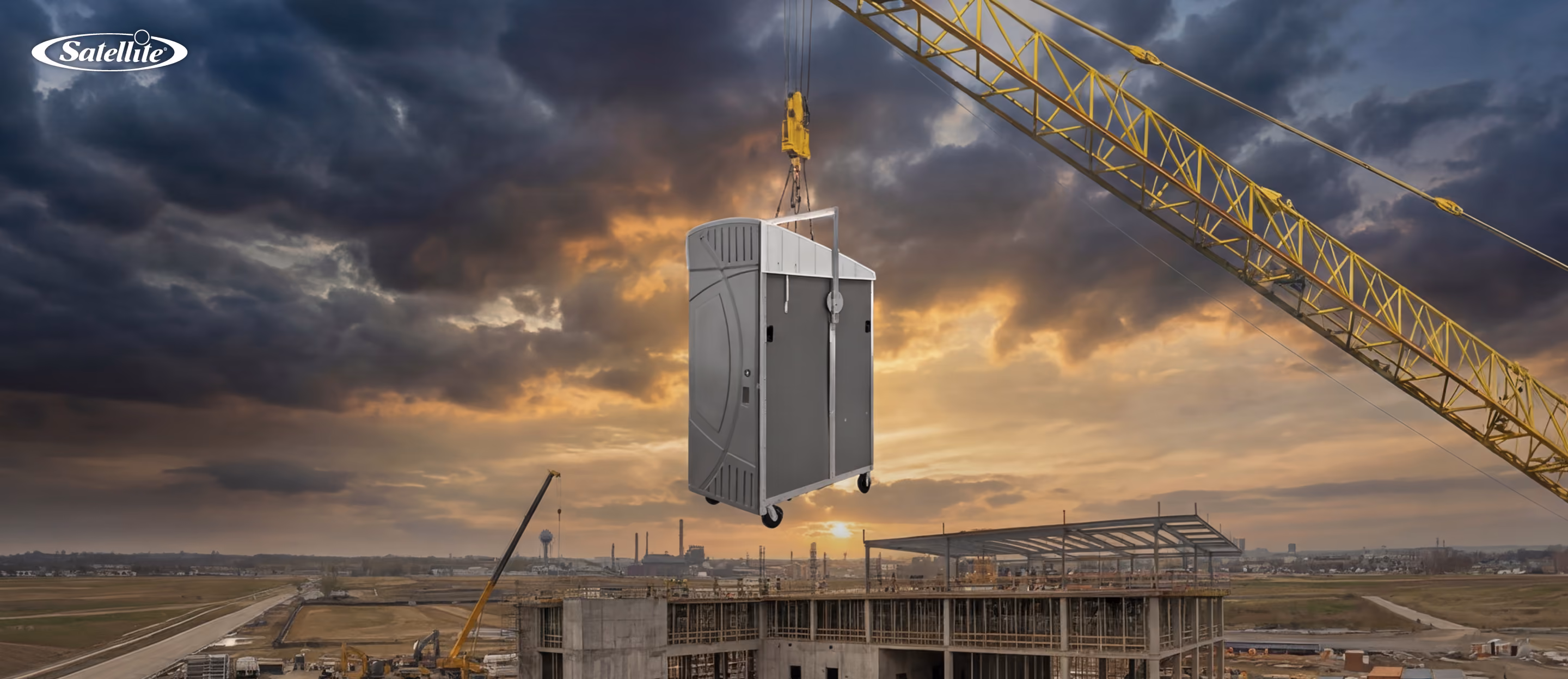 High-rise portable restroom being lifted by crane onto a multi-story construction site, demonstrating portable sanitation solutions for construction projects, worker productivity, jobsite safety, compliance, and efficient access to restroom facilities on large commercial builds.