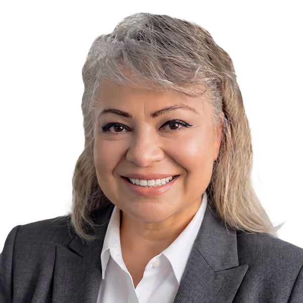 Professional woman with short, light hair wearing a gray blazer and white shirt, smiling warmly.