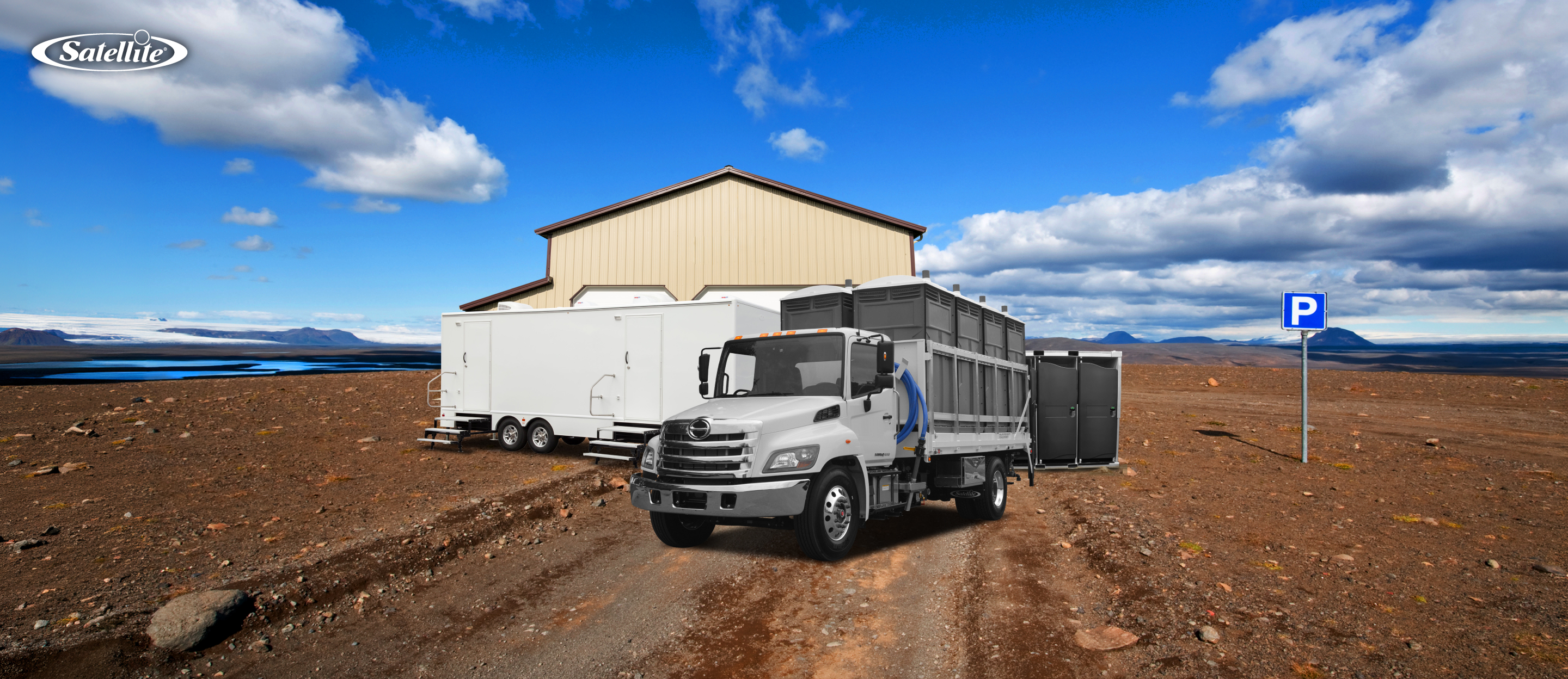 Satellite Industries portable sanitation equipment, including restroom trailers, portable restrooms, and a service truck, staged at a remote project site. The image represents portable sanitation business opportunities in construction, mining, industrial operations, disaster response, outdoor events, and emerging global markets.