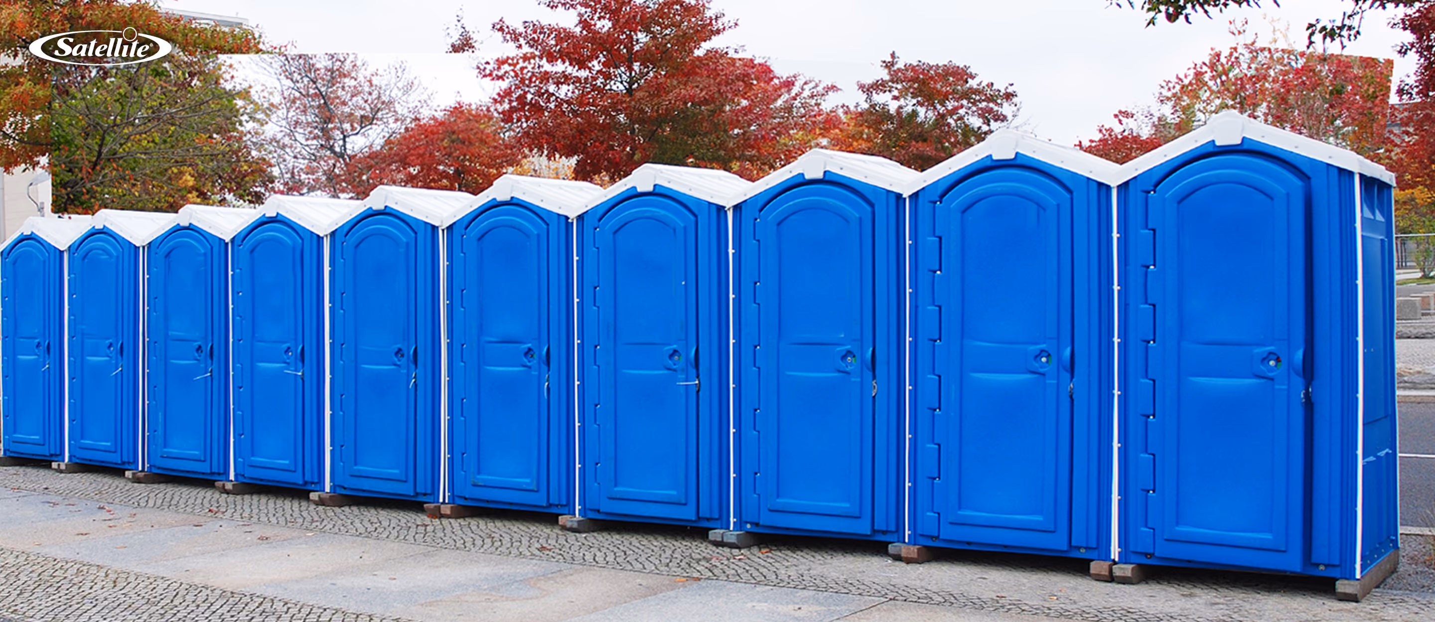 Row of blue portable toilets installed outdoors, showcasing durable portable toilet solutions for construction sites, outdoor events, festivals, parks, and portable restroom rental operations designed for reliable sanitation and easy servicing.