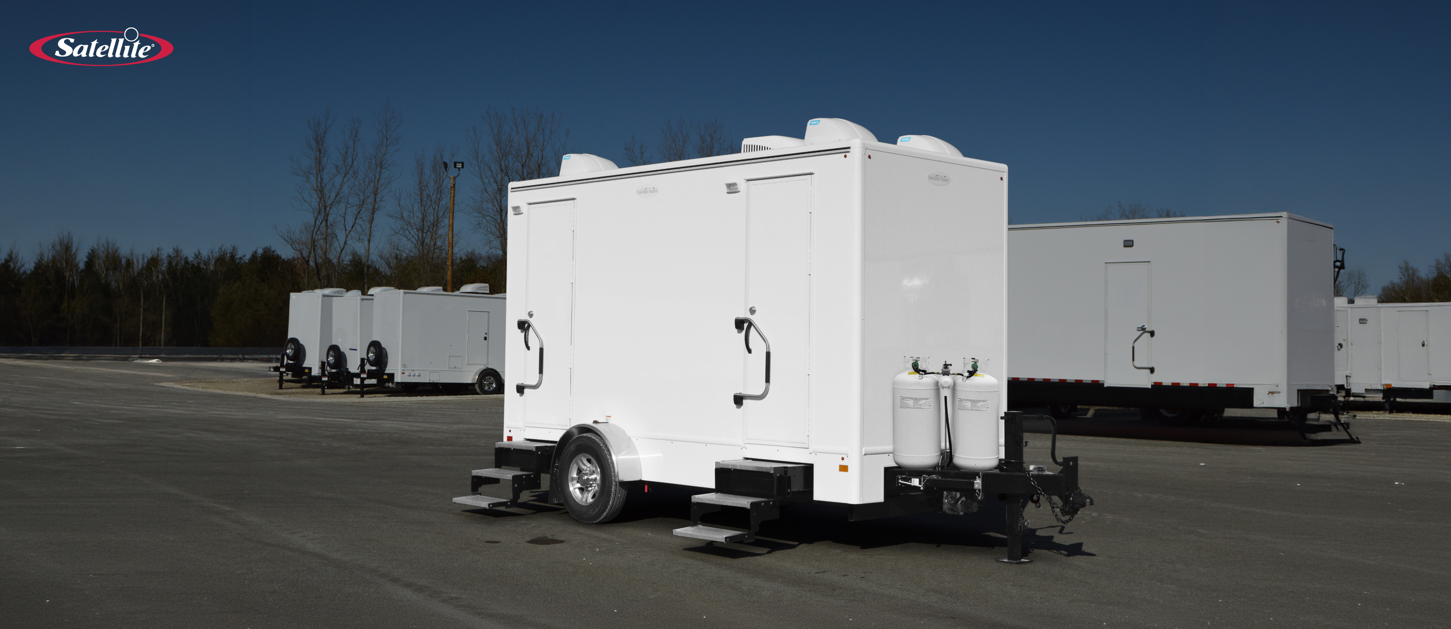 Satellite Industries multi-stall mobile shower trailer at an outdoor event, providing private portable shower facilities for temporary sanitation, festivals, remote worksites, disaster response, and other large-scale deployments.