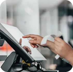 Person interacting with a touchscreen point-of-sale system while holding a receipt.