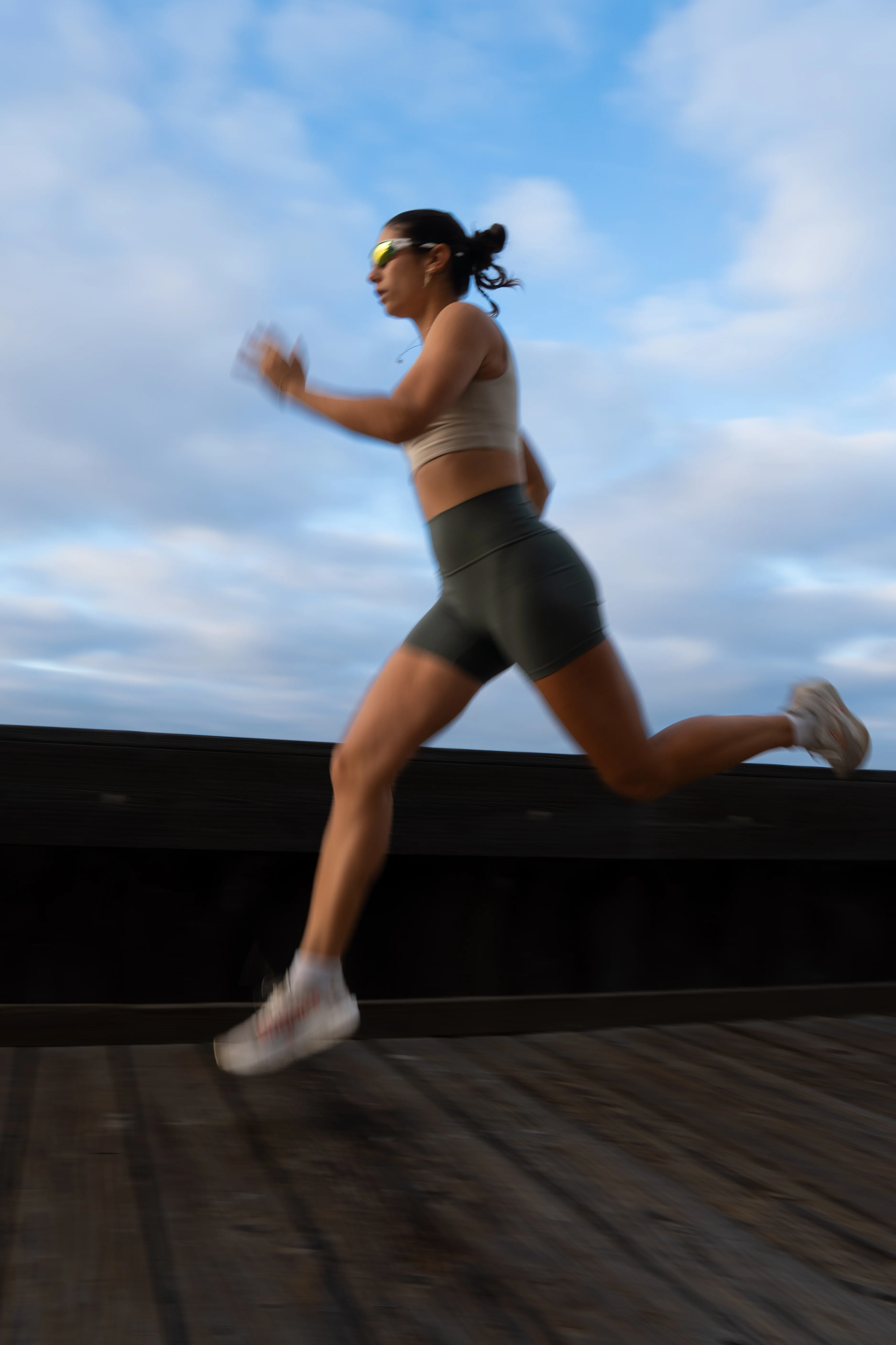 A girl running on a boardwalk.