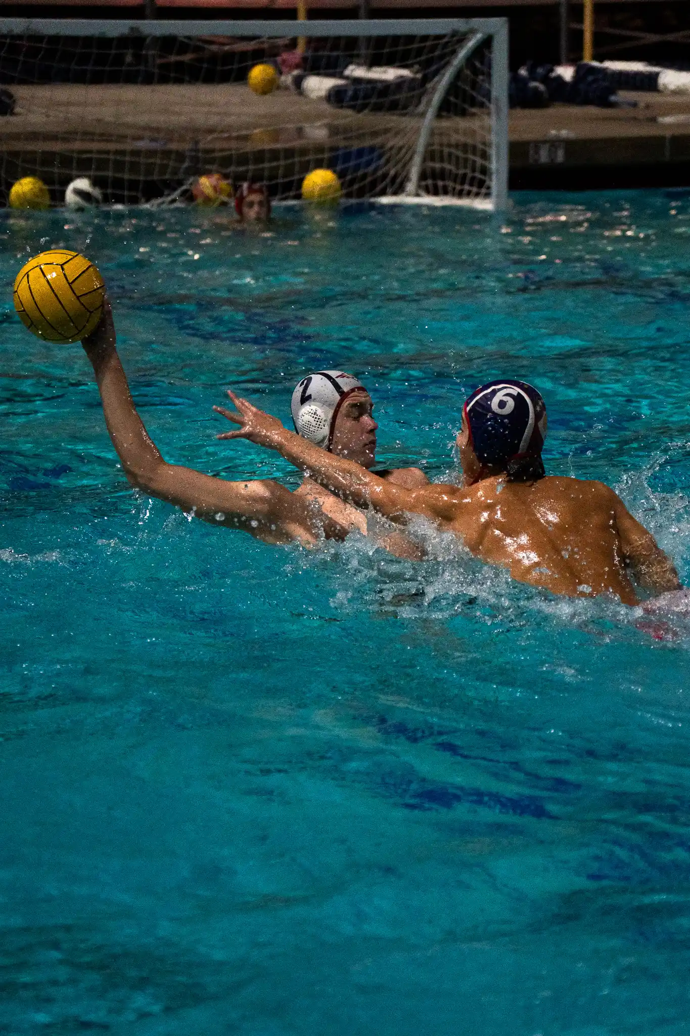 Two boys playing water polo.