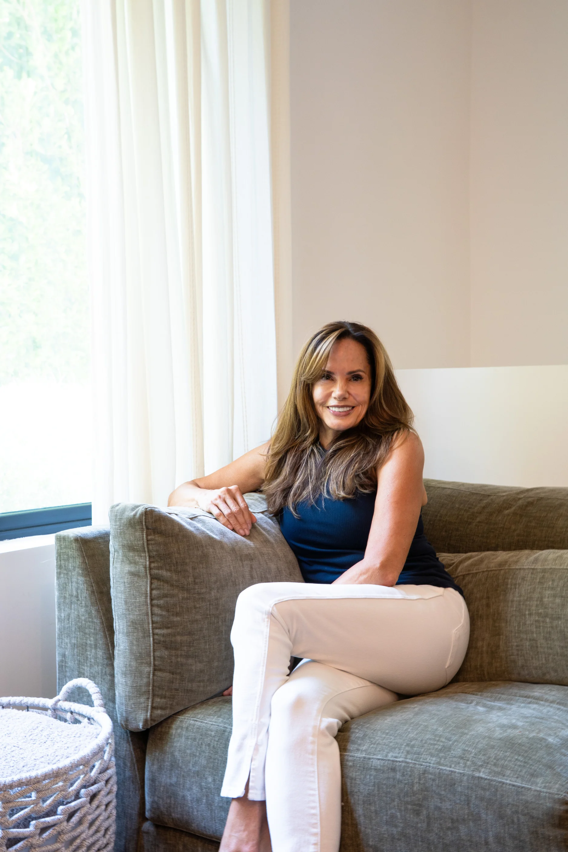 A woman sitting on a green couch.