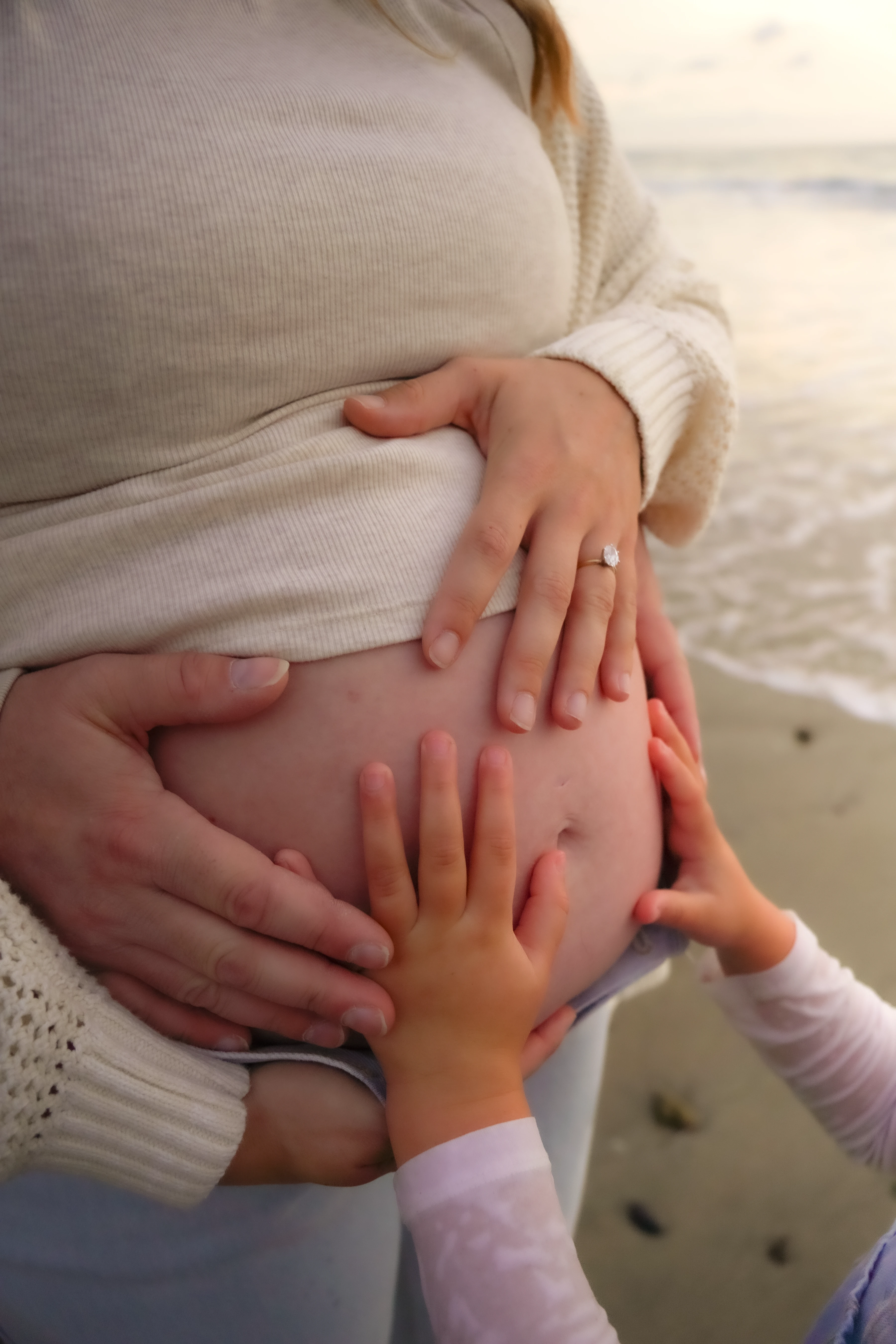An engagement shoot, capturing a man and women holding hands, showcasing her new diamond.