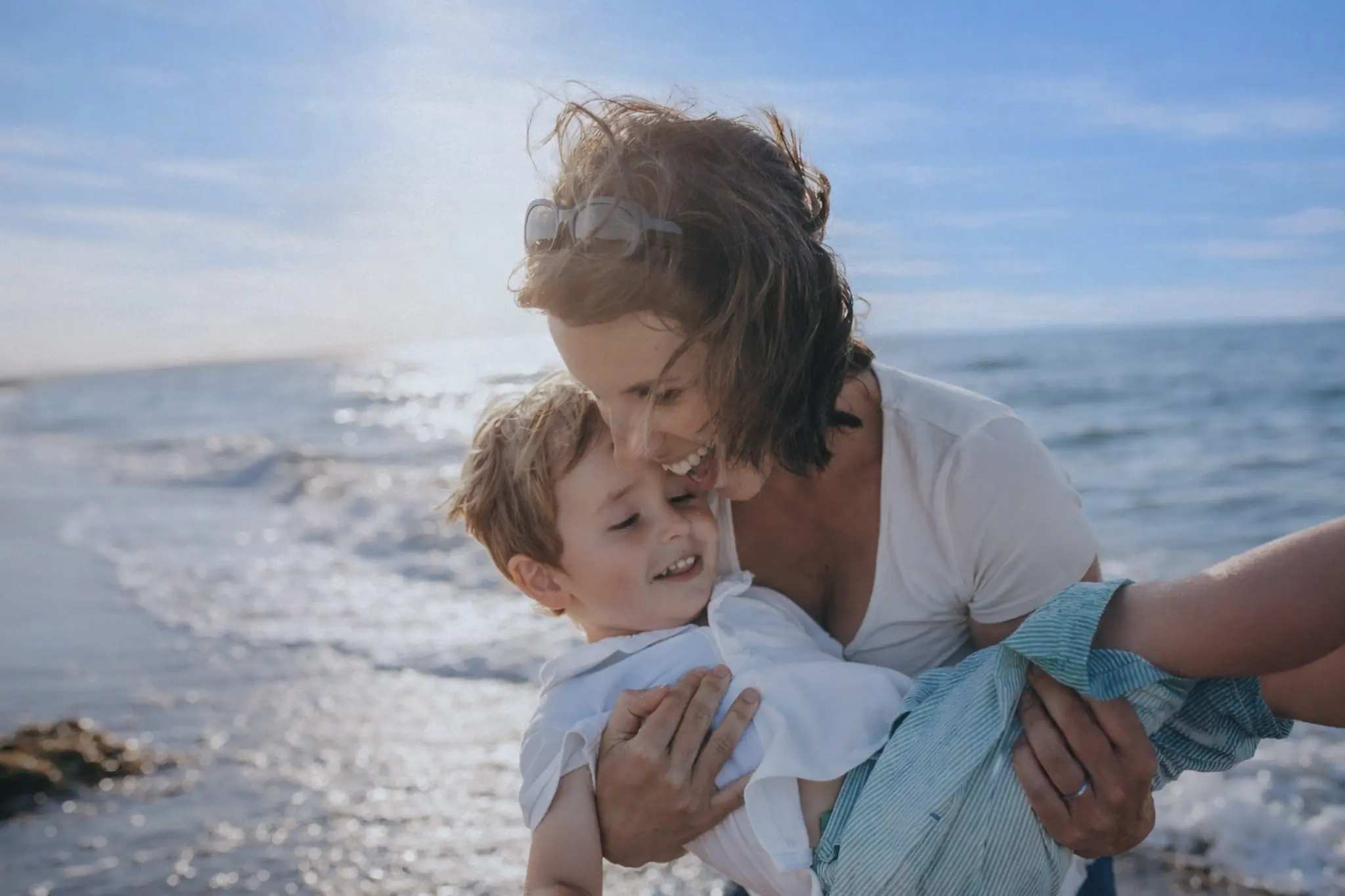 Mother smiling with young child at the beach