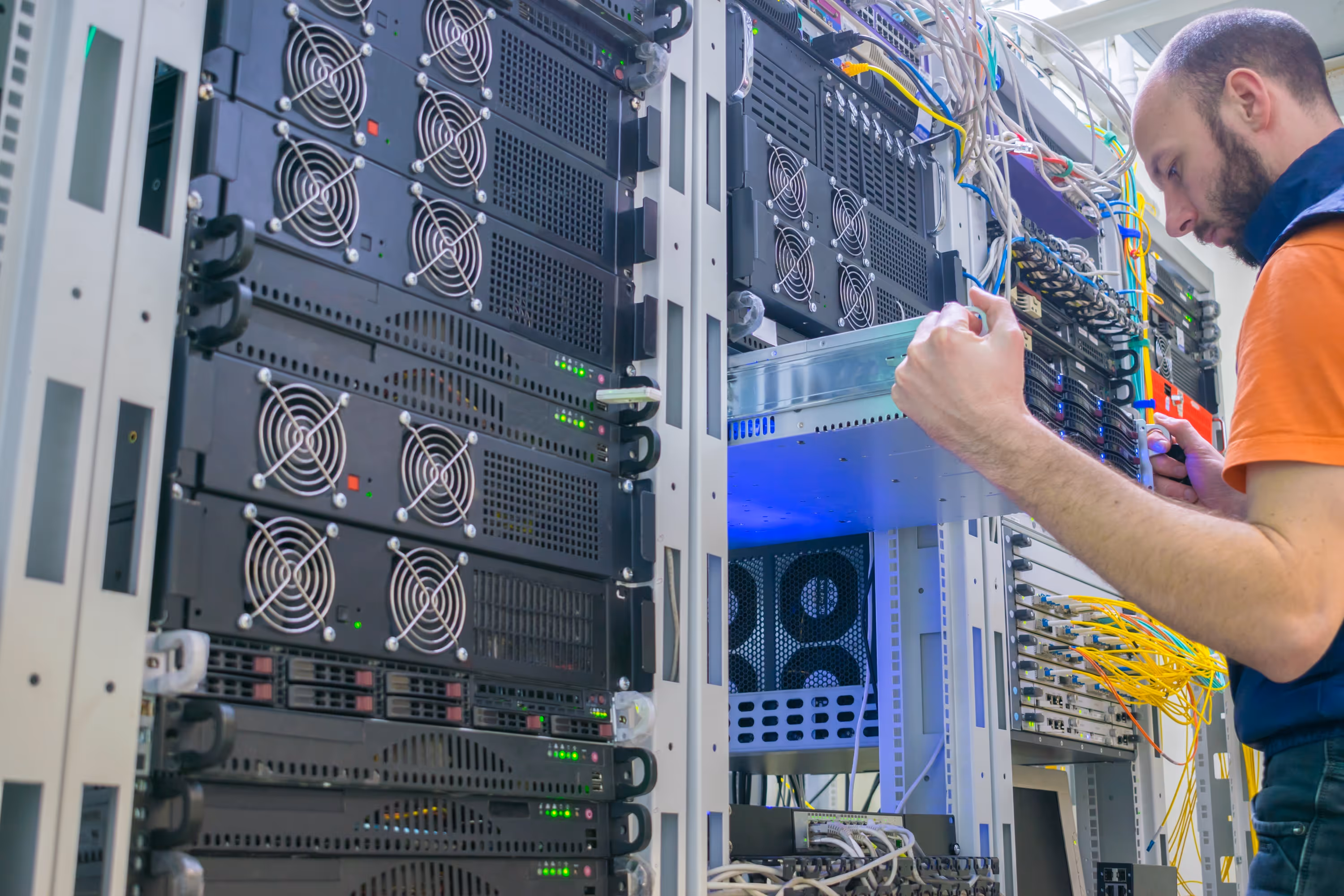 Network technician working on cabling in a data center server rack