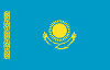 Flag of Kazakhstan with a blue field, a yellow sun with rays, and a soaring eagle beneath it, plus a vertical ornamental pattern on the left.