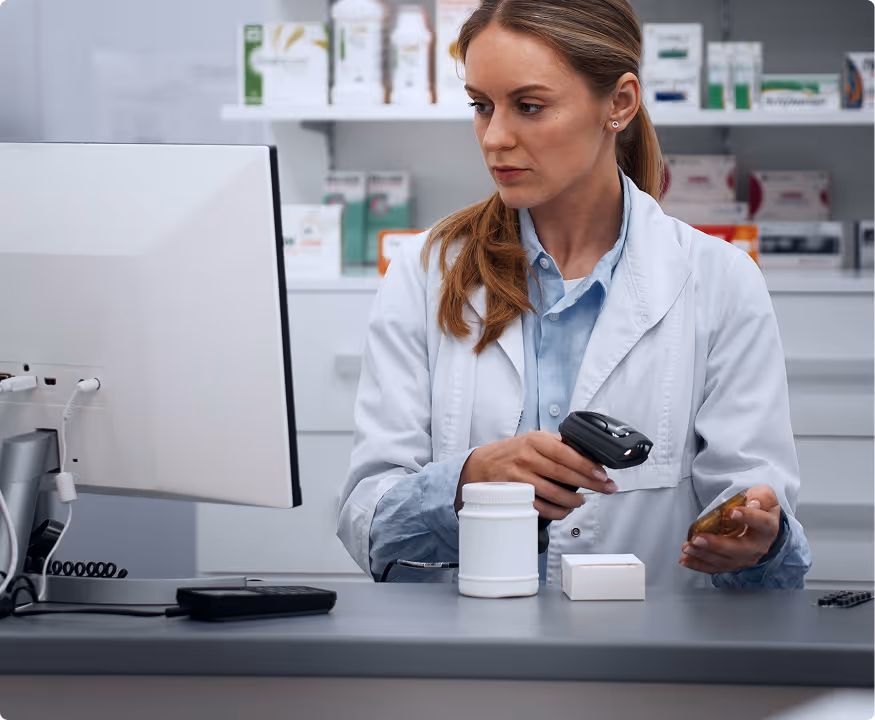 Pharmacist scanning medication with a handheld barcode scanner in a pharmacy.