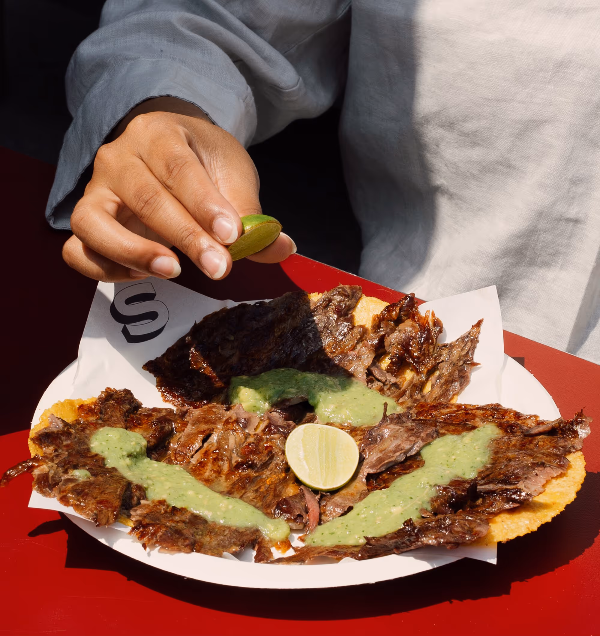 Adding lemon to The Santi's Steak Trompo Taco