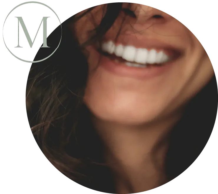 Woman's smile in a circular frame with the Masters Dentistry M logo