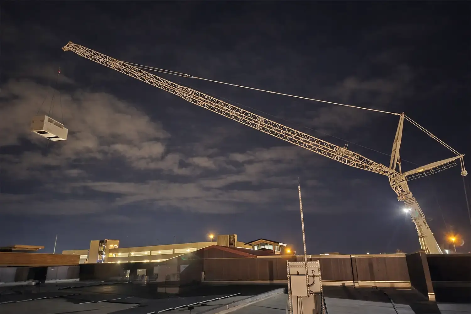 Multiple HVAC units installed on a flat rooftop of a commercial building under a cloudy sky.