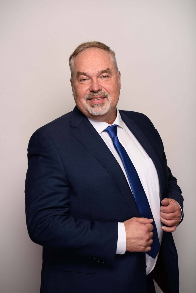 Rechtsanwalt Weidner im Porträt, lächelnd, aufrecht stehend