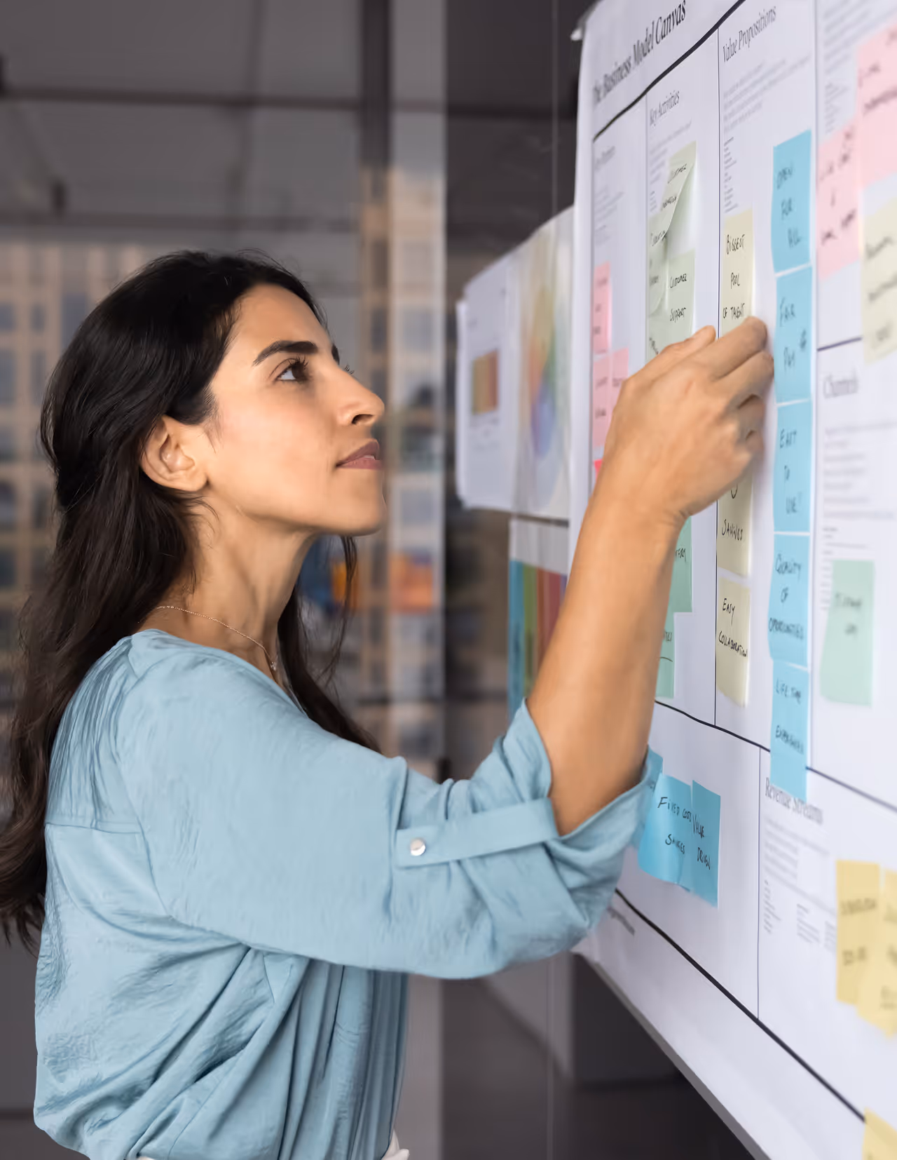 Person organizing sticky notes on a planning board during a privacy focused policy design session.