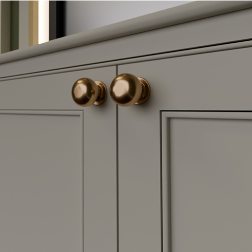 Close-up of gray cabinet doors with round metallic bronze knobs.