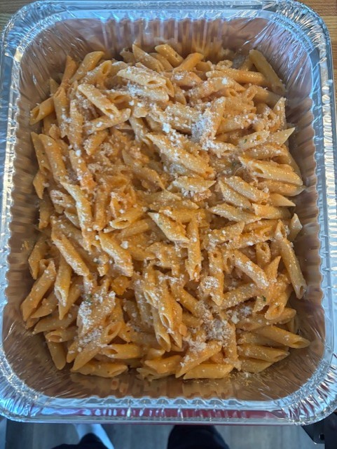 Burger with fried fries on black plate with sauce on the side