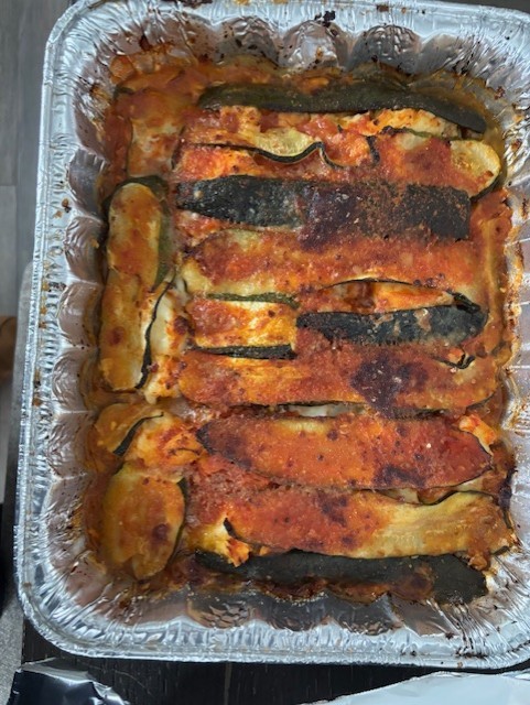 Burger with fried fries on black plate with sauce on the side