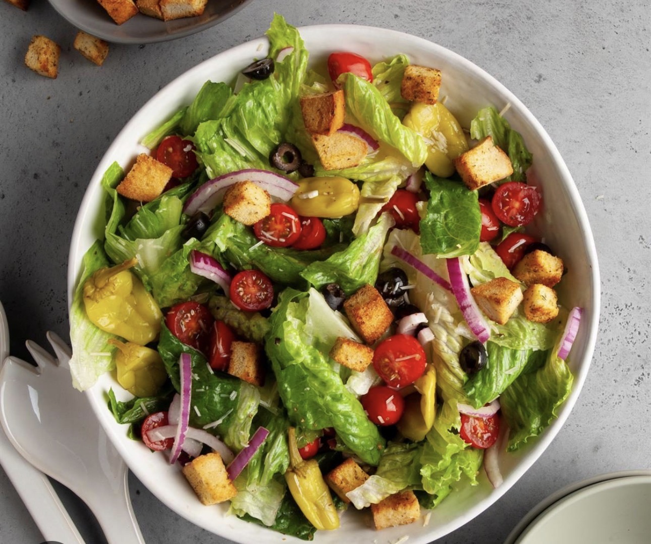 Burger with fried fries on black plate with sauce on the side