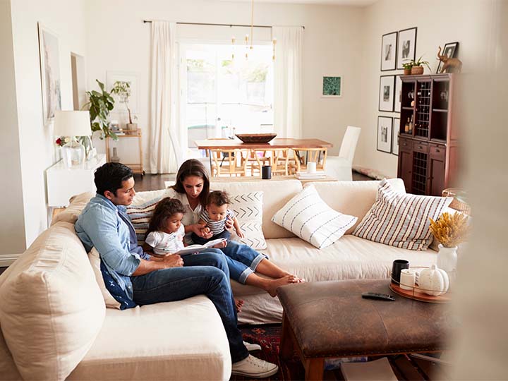 A young family reading together on the couch of their home with great indoor air quality