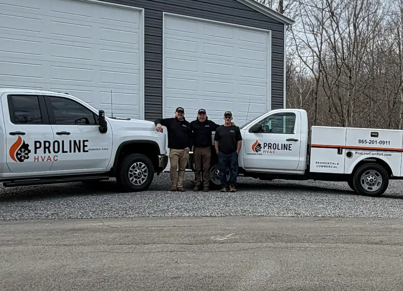 Proline HVAC technicians standing by their fleet vehicles