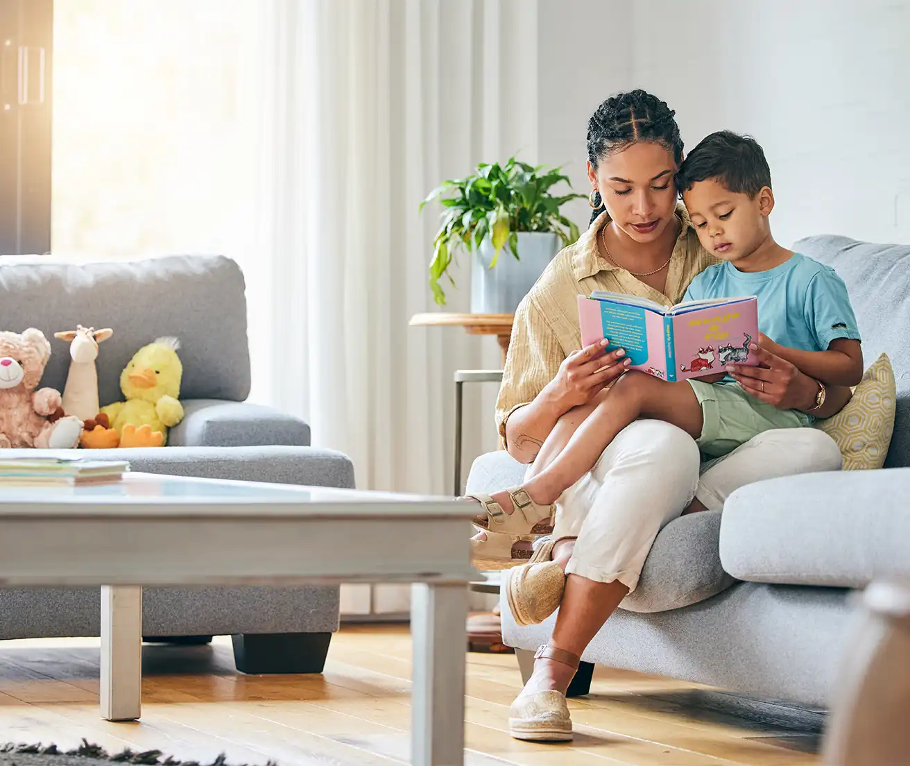 A mother reading to her child on the couch in a comfortable living room