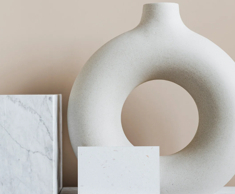 High-end interior design detail at West Main featuring a circular ceramic vase and marble accents on a neutral shelf.